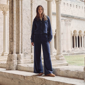  Person wearing a blue outfit standing in front of classical architecture