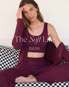  Woman in burgundy outfit sitting on a checkered couch with 'The Soft Life' text overlay.
