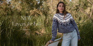  Woman wearing a patterned sweater standing in a natural setting with text 'NEW Layers for Fall'.