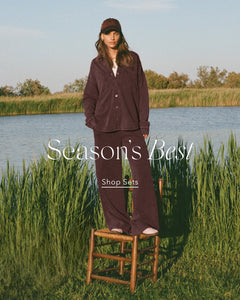  Person wearing a brown outfit standing on a stool by a lake with 'Season's Best' text overlay.