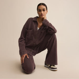 DressesMelbourne Sandy Bay Palm Midi Dress Person wearing a brown oversized shirt and pants on a beige background