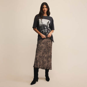 SweatersLooking Glass Crochet Polo Sweater Woman wearing a graphic t-shirt and leopard print skirt on a beige background