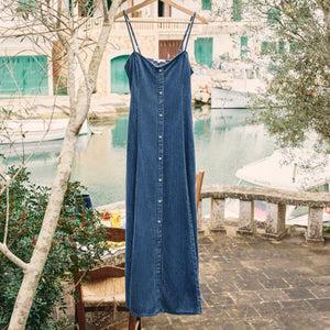 SweatersLooking Glass Crochet Polo Sweater Blue dress on a hanger with a scenic background of a canal and buildings.