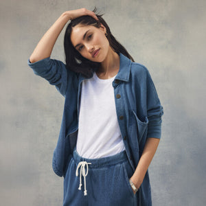 DressesMelbourne Sandy Bay Palm Midi Dress Woman wearing a blue denim outfit with a white shirt against a gray background