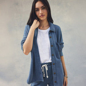 TopsSirena Rib Tank Woman wearing a denim jacket over a white shirt and blue pants on a gray background