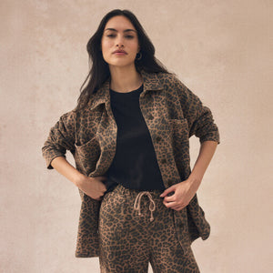 Woman wearing a leopard print outfit against a beige background