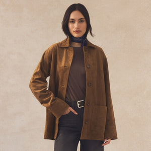 Woman wearing a brown coat against a beige background