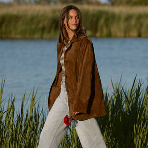  Woman standing by a body of water with tall grasses in the foreground