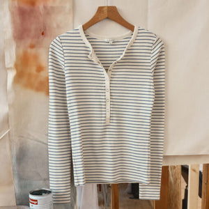  Striped long-sleeve shirt on a hanger against a neutral background