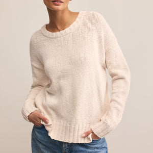 DressesMelbourne Sandy Bay Palm Midi Dress Person wearing a beige sweater and blue jeans against a plain background