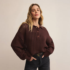 Woman wearing a brown textured sweater against a beige background