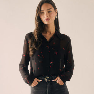  Woman wearing a black sheer blouse with red patterns on a beige background