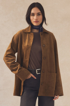Woman wearing a brown jacket with a neutral background